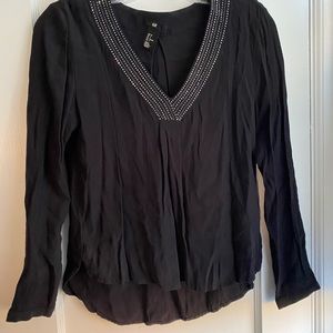 H&M black blouse with studded neckline.